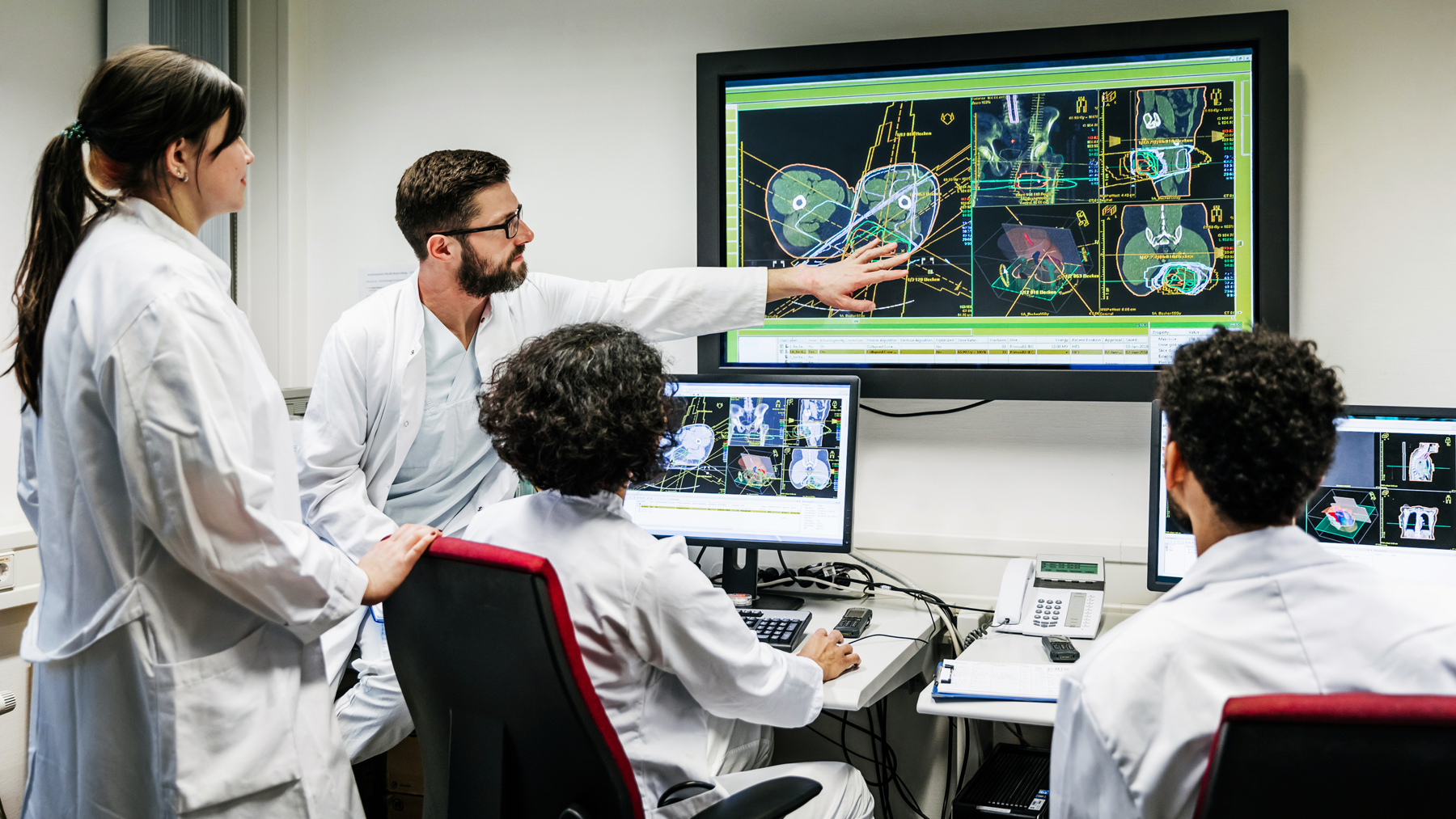 health care researchers reviewing test results on a large screen