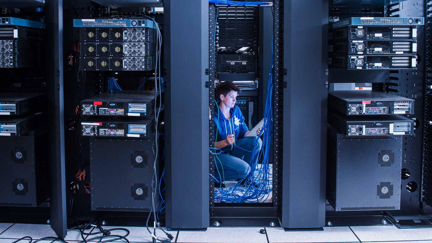 female engineer inspecting data storage racks